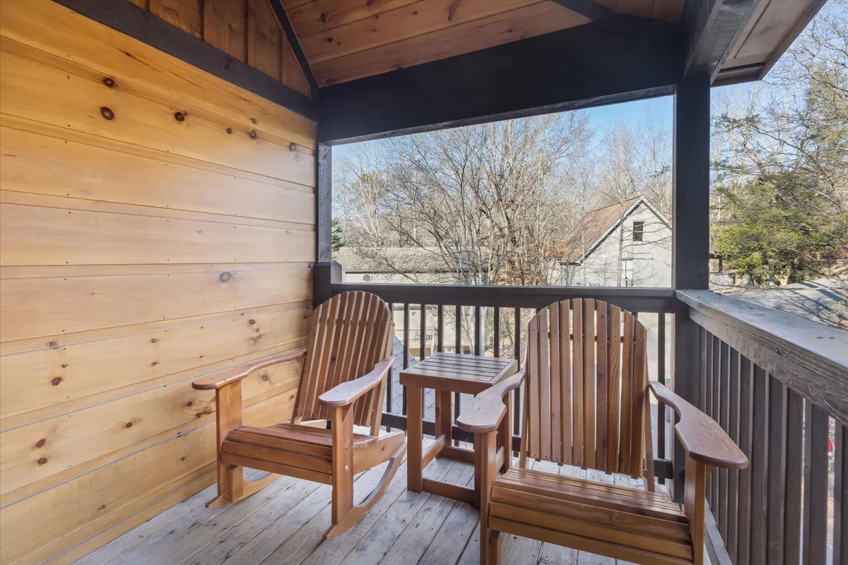 This exterior scene captures two wooden chairs and a small table set on a porch or deck, surrounded by lush natural scenery. The tranquil setting invites guests to relax outside and enjoy the peaceful mountain atmosphere, perhaps while sipping coffee or watching the sunset.